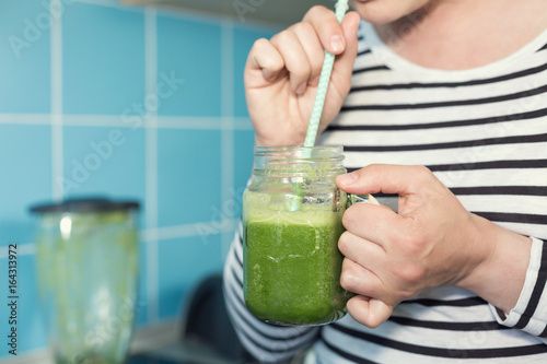Female tasting healthy green smoothie