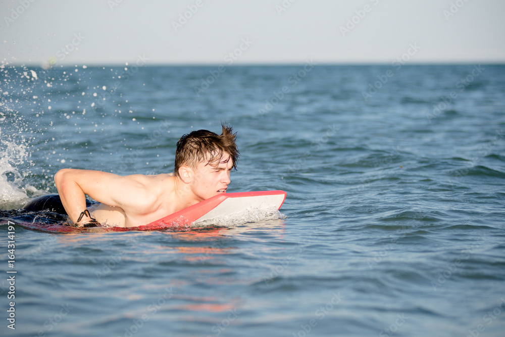 Teenage boy with a body board in the sea