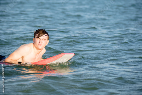 Teenage boy with a body board in the sea © Ben Gingell