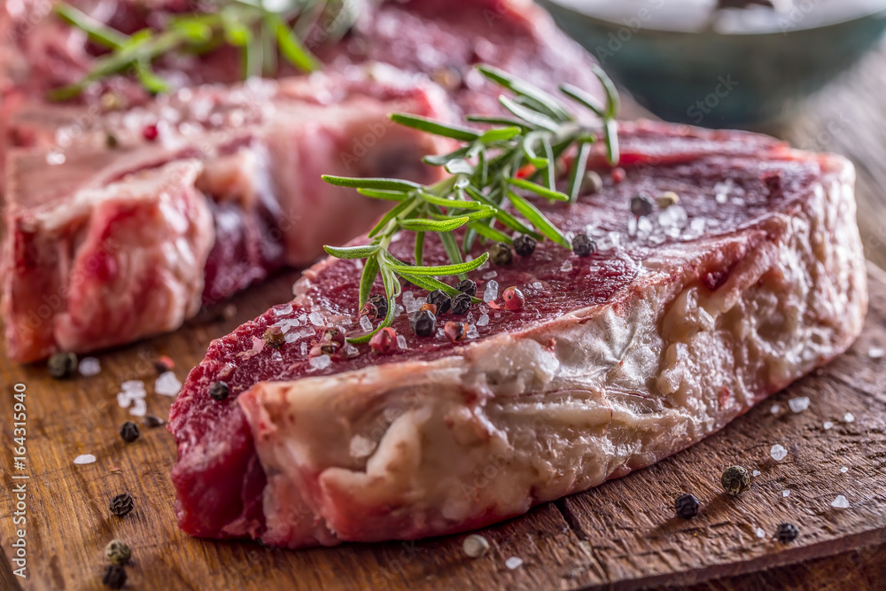 Beef raw steak. Raw fresh T-bone steak with salt pepper and rosemary