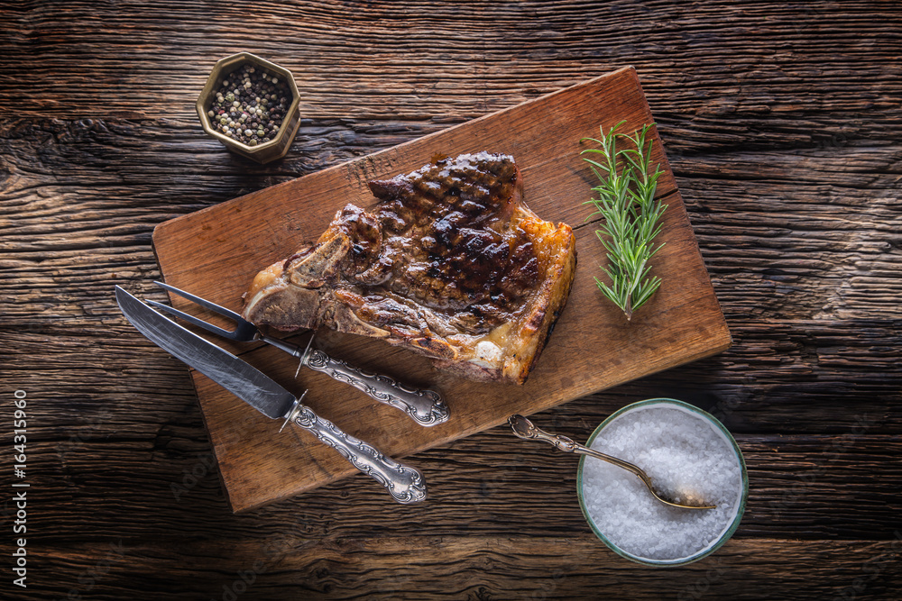 Grill juicy beef T-bone steak with salt pepper and rosemary Grill juicy beef T-bone steak with salt pepper and rosemary