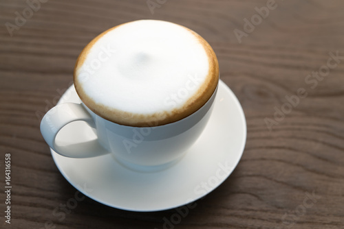 Hot cappuccino coffee on wood table.