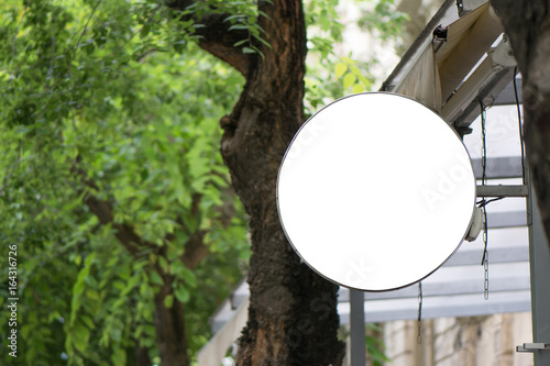 Blank round signboard, hanging from the facade of a terrace