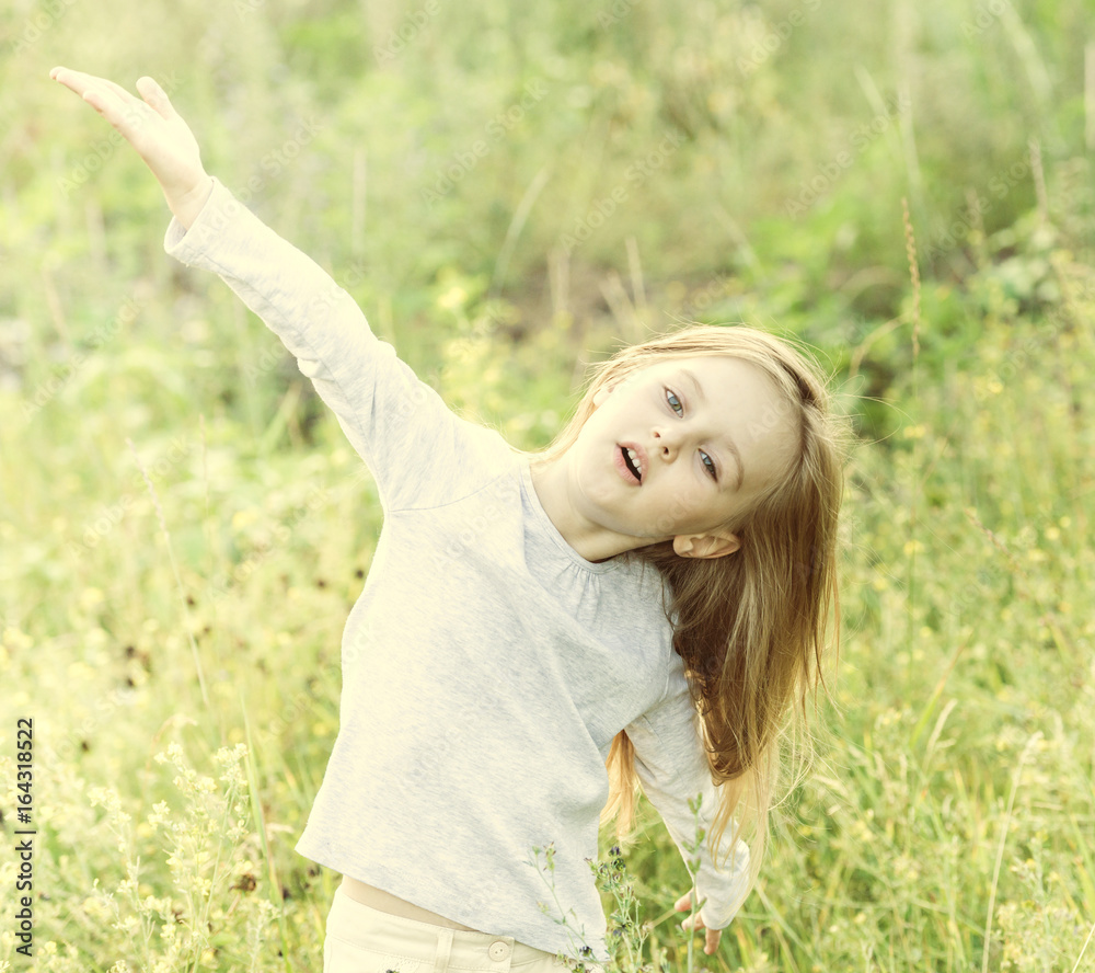 child in field among flowers and herbs, smiling child in field among flowers and herbs, smiling