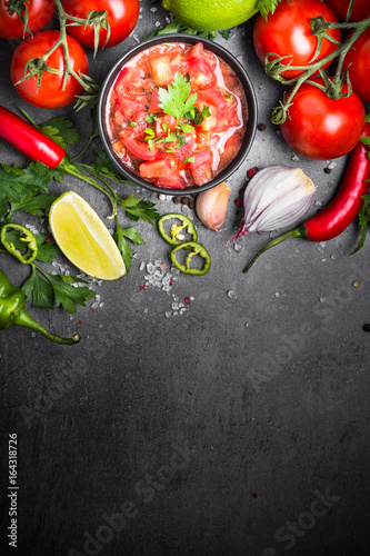 Traditional Latin American mexican salsa  sauce. Top view on black table.