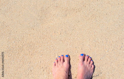 Woman feet on white sand. White coral beach by sea. Sunny tropical seaside.