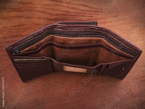 Empty purse on a wooden background; Open women's wallets