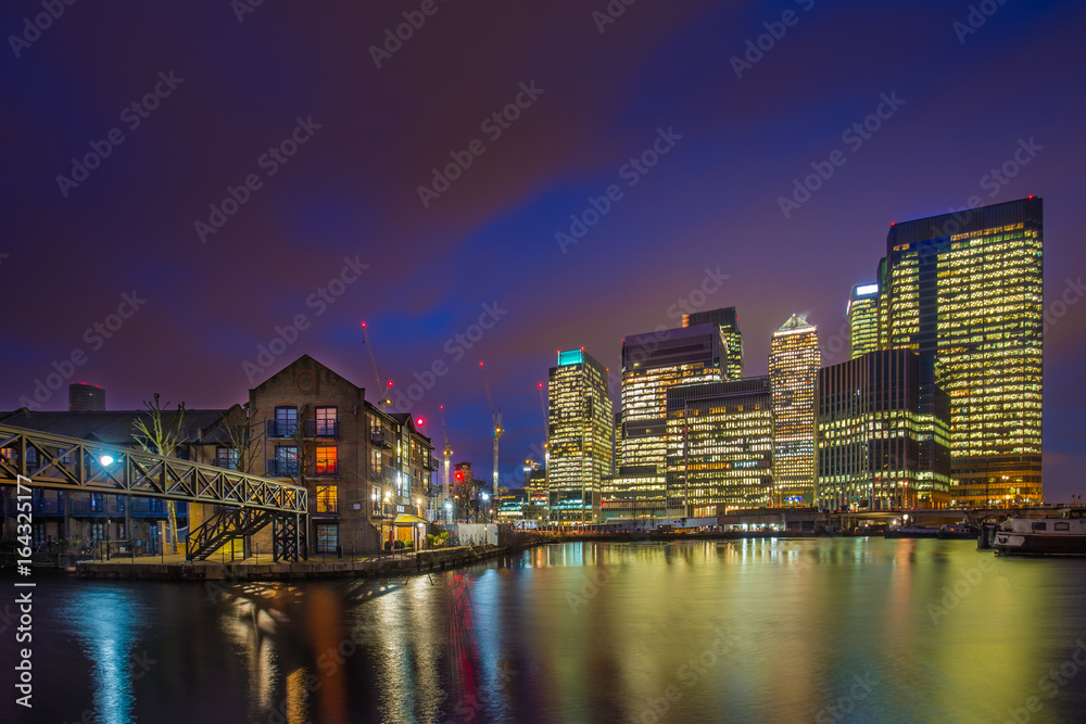 London, England - The skyscrapers of Canary Wharf financial district and residential buildings at the docklands of London by night