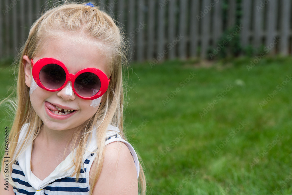 adorable school age girl with sunscreen and sunglasses on outside in summertime adorable school age girl with sunscreen and sunglasses on outside in summertime
