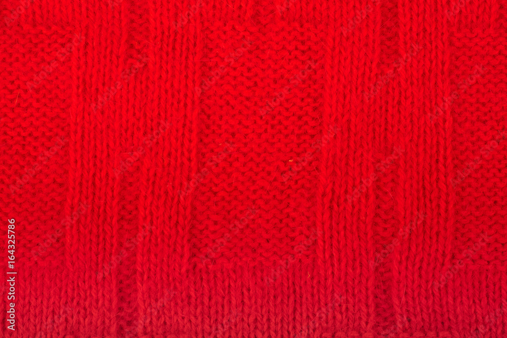 Sweater or scarf fabric texture large knitting. Knitted jersey background with a relief pattern. Wool hand- machine, handmade. red.