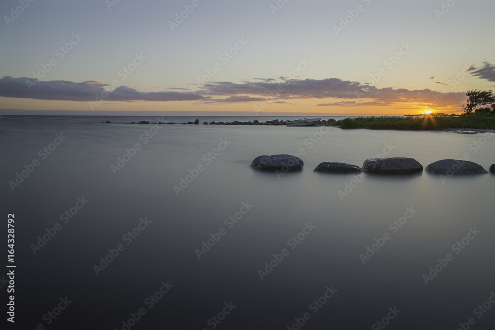 Fototapeta premium Sunset over Ocean with Breakwater