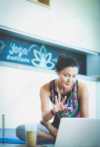 Sporty smiling woman using laptop in bright room. Woman. Lifestyle photo