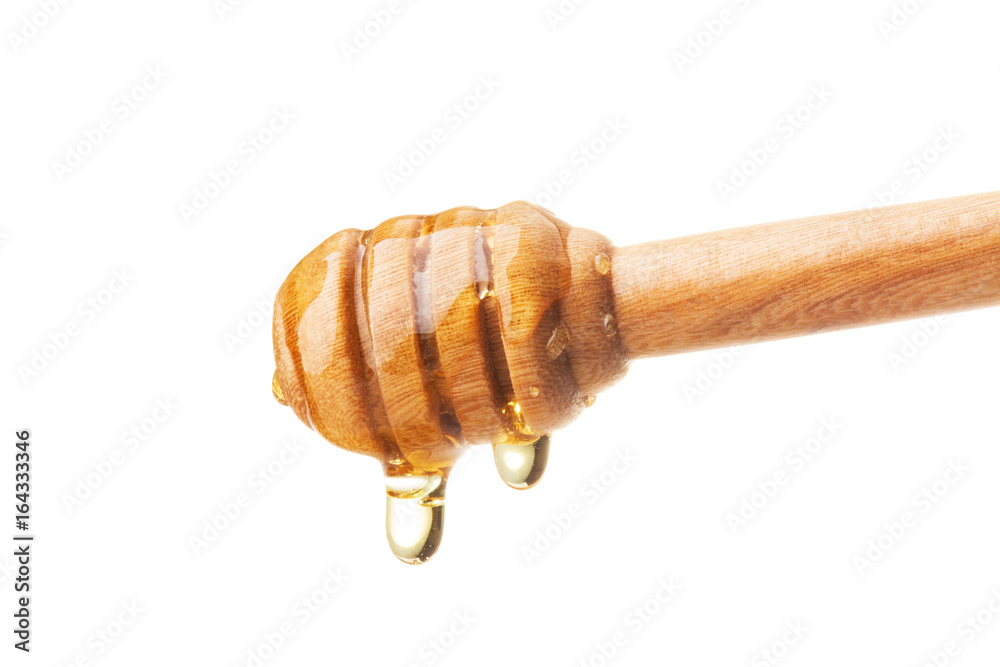 Honey dripping from a wooden dipper on isolate white background. ready to use with clipping path.