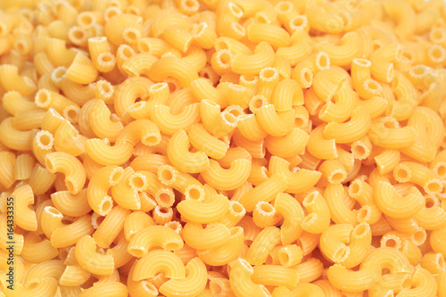 A seamless raw food texture of dry uncooked macaroni pasta