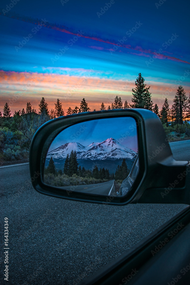 Reflection in rear view mirror of mountain sunset