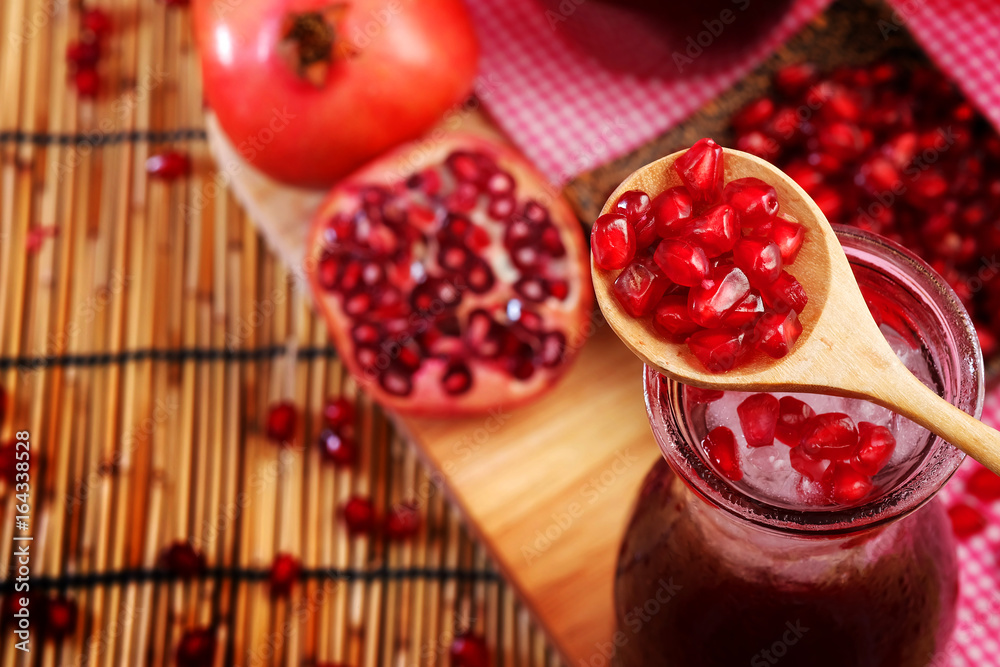 Pomegranate Set. Good healthy by Pomegranate seed on wooden spoon and cool Pomegranate juice set on red Themes tone background. have some space for write wording Pomegranate Set. Good healthy by Pomegranate seed on wooden spoon and cool Pomegranate juice set on red Themes tone background. have some space for write wording