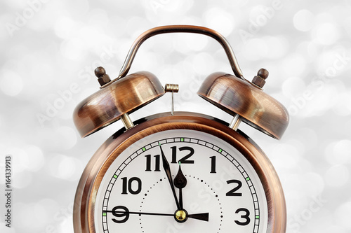 Retro the alarm clock of bronze color at twelve o'clock