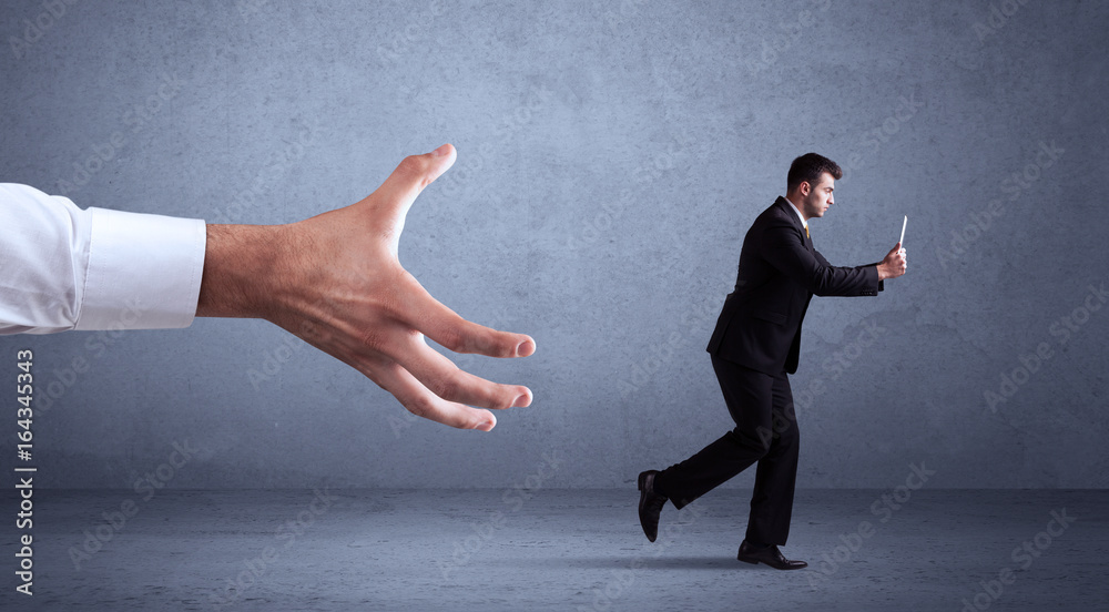 Fototapeta premium Businessman running from hand