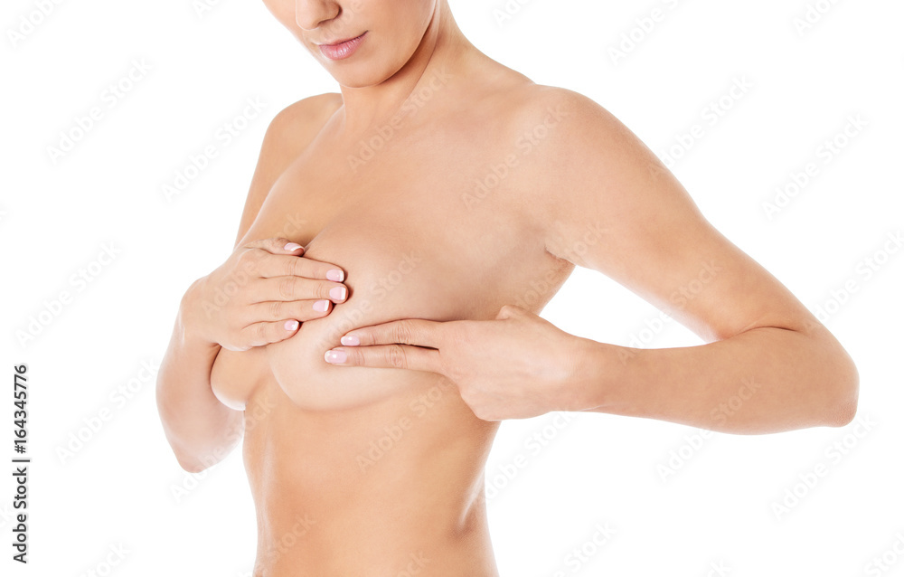 Fototapeta premium Young woman examining her breast for lumps or signs of breast cancer.