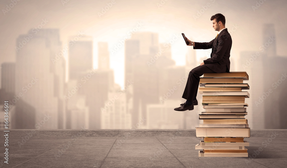 Man above the city sitting on books Man above the city sitting on books