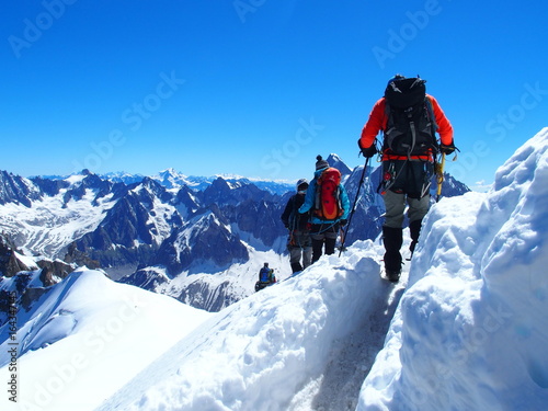 Four alpinists and mountaineer climber on Aiguille du Midi
