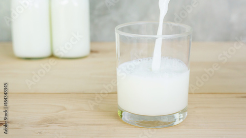 man pouring a milk on a wooden table.