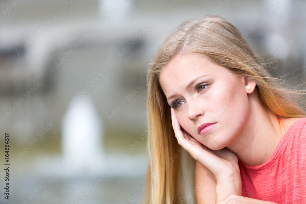 Pensive beautiful girl with blond hair. Copy space