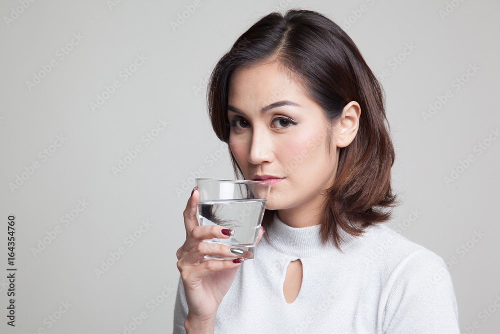 Young Asian woman with a glass of drinking water. Young Asian woman with a glass of drinking water.