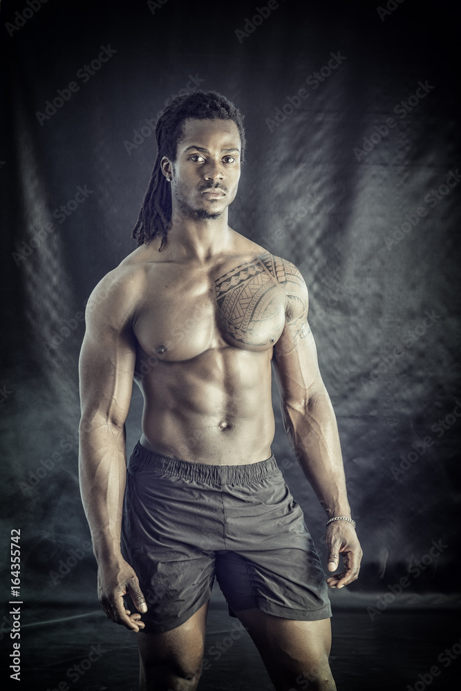 African American bodybuilder man, naked muscular torso, wearing underwear, against black background