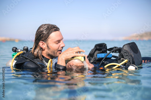 Scuba diver doing a rescue procedure on a girl