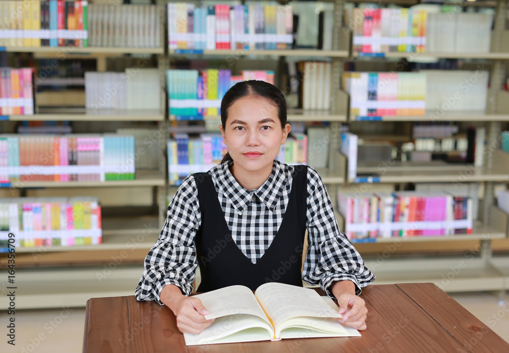 Young asian woman reading book in the library. Young asian woman reading book in the library.