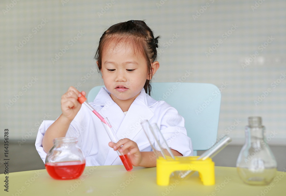 Asian child in scientist uniform holding test tube with liquid isolated on white background, Scientist chemistry and science education concept. Asian child in scientist uniform holding test tube with liquid isolated on white background, Scientist chemistry and science education concept.