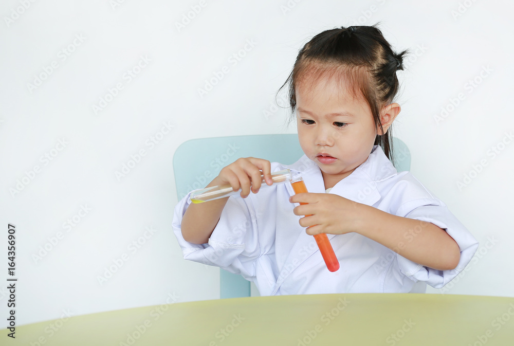 Asian child in scientist uniform holding test tube with liquid, Scientist chemistry and science education concept. Asian child in scientist uniform holding test tube with liquid, Scientist chemistry and science education concept.