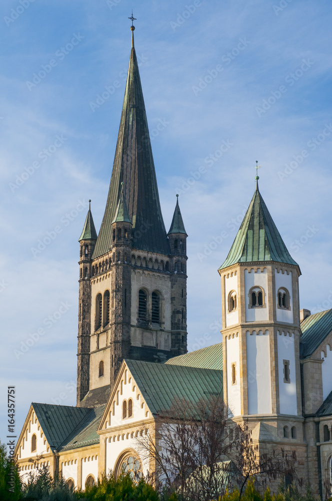 Outside of a old white Church with green roof.