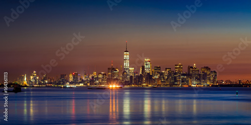 First light of the day on Lower Manhattan skyscrapers from New York City Harbor. Financial District and Midtown West