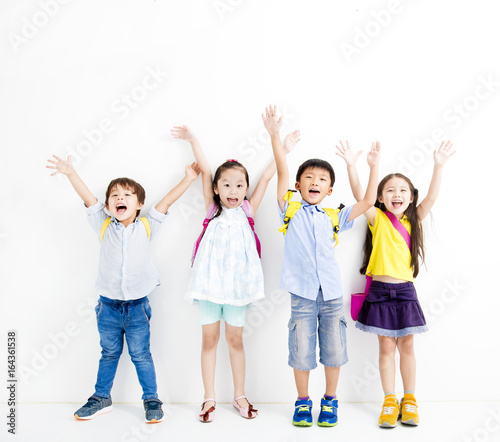 Group of happy smiling kids raise hands