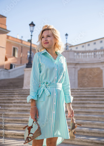 young attractive blond woman barefoot in the spanish stair in Rome and look away 