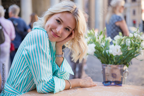 Photography young blond woman look and smile in the morning seeting in a street cafe in Rome