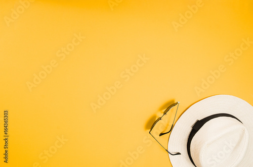 Accessories for travel top view on yellow background with copy space. Beach adventure and wanderlust concept image with travel accessories. Sunbathing and relaxing