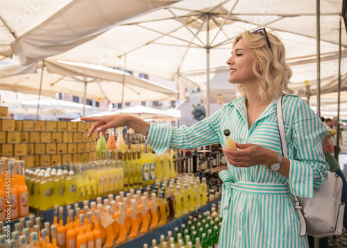 Photography Attractive blond woman on the market choose beverages