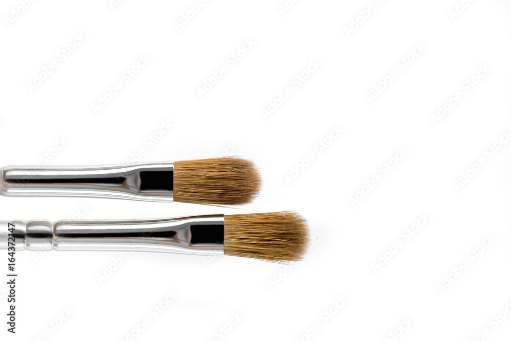 Two makeup brushes on white background, top view Two makeup brushes on white background, top view