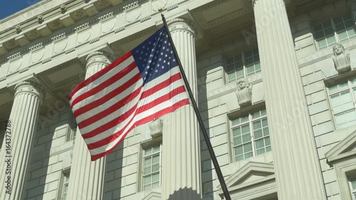 Low angle view of US National Flag on facade of US Department of Commerce in Washington DC