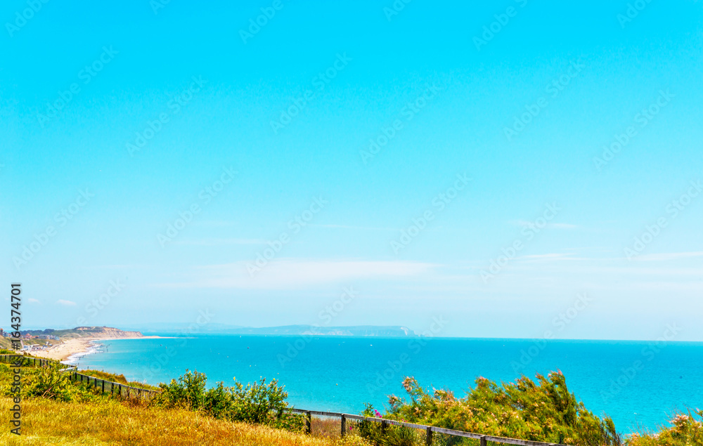 Ocean view with hills, green vegetation background and beautiful blue ocean tile