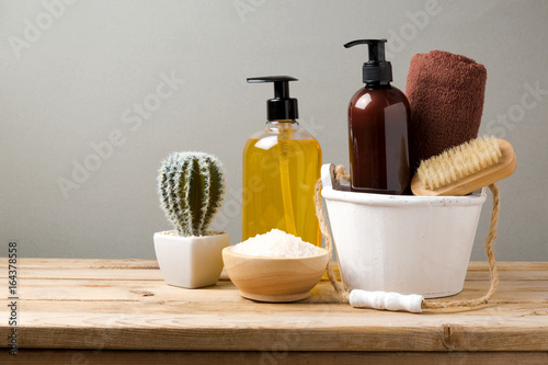 Body care products on wooden table over gray background