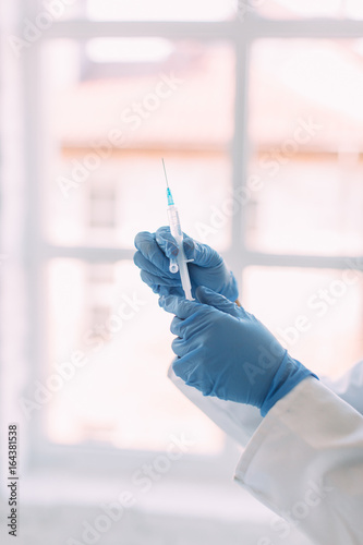 Hand of doctor holding a syringe