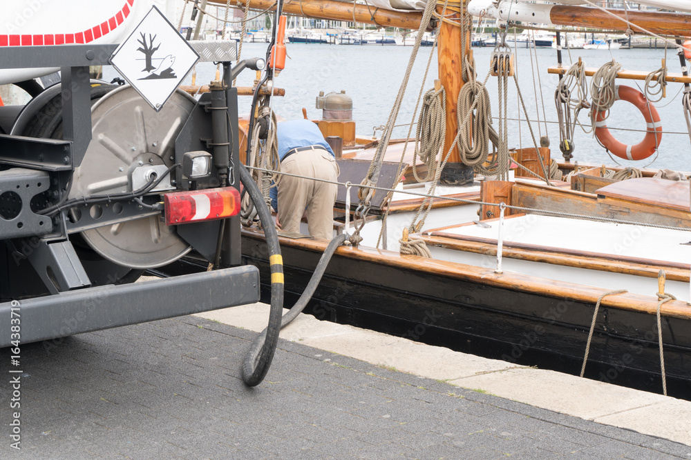 Ein Segelschiff wird im Hafen mit Diesel betankt Ein Segelschiff wird im Hafen mit Diesel betankt