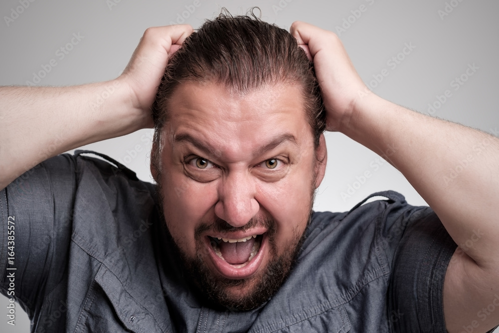 Closeup portrait of angry, frustrated man, pulling his hair out. Negative human emotions and facial expressions Closeup portrait of angry, frustrated man, pulling his hair out. Negative human emotions and facial expressions