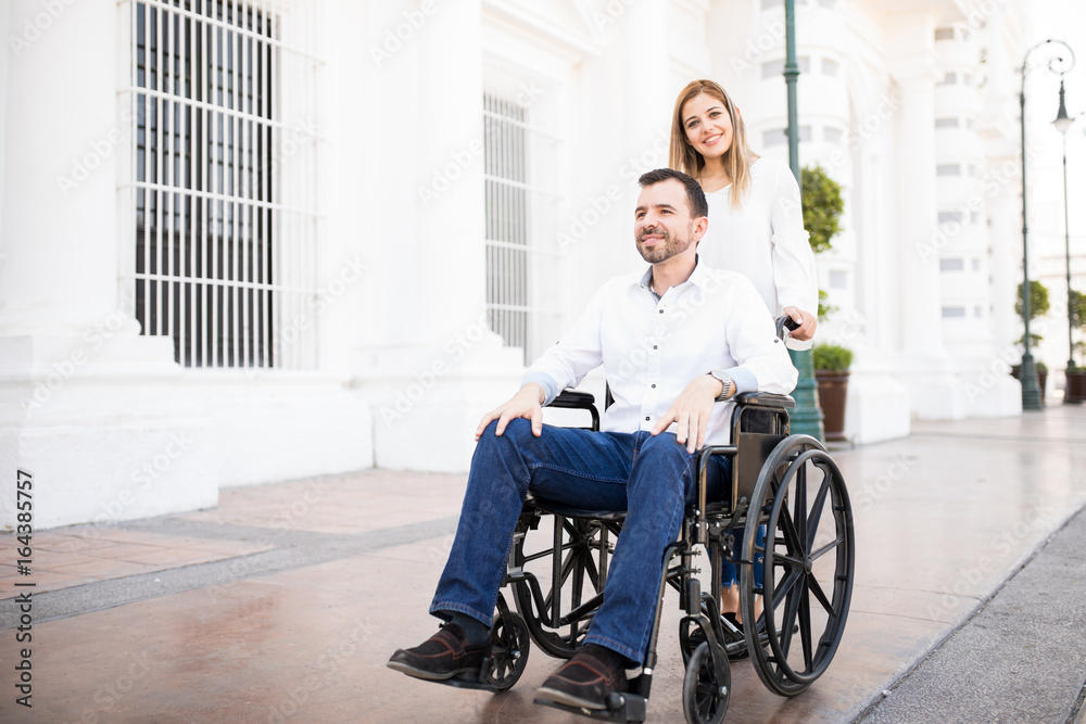 Woman pushing her boyfriend's wheelchair