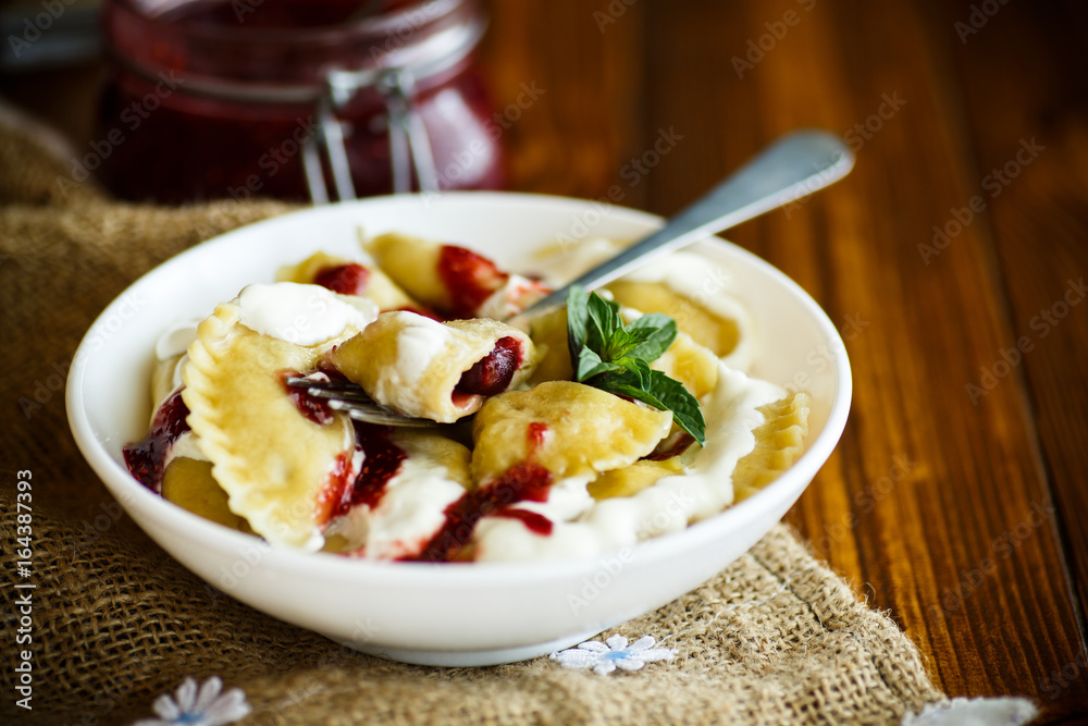 Homemade sweet dumplings with berries and sour cream