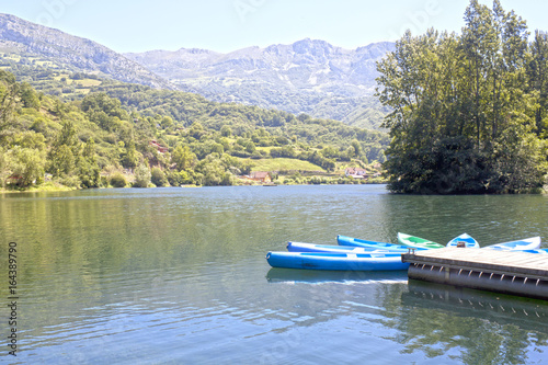 Canoes in a lake near a village surrounded of trees